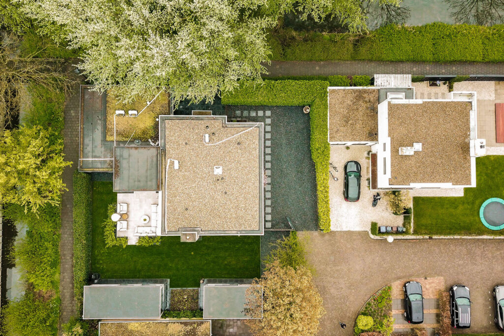 an aerial view of a house with a pool in the fore - image is taken from above, looking down