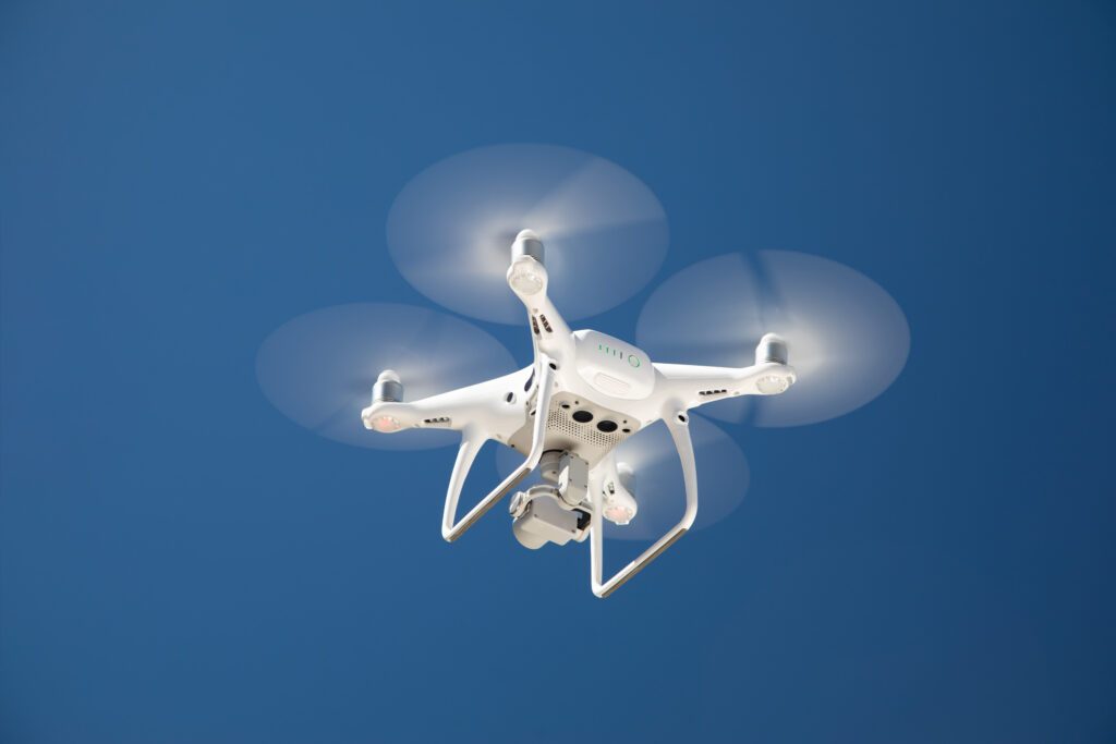 Drone Quadcopter From Below Against A Blue Sky.
